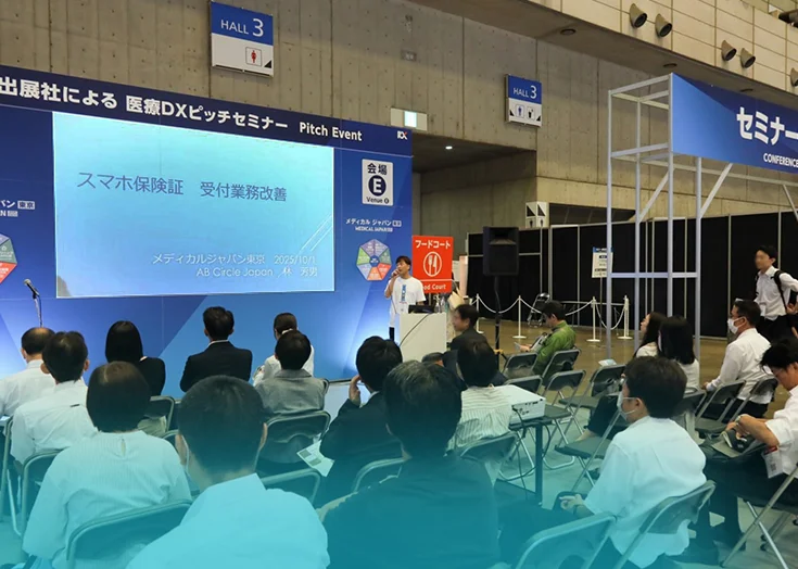 AB Circle Japan、Medical Japan 2025でマイナンバーカード認証を効率化する革新的なスマートフォン専用リーダースタンドを展示